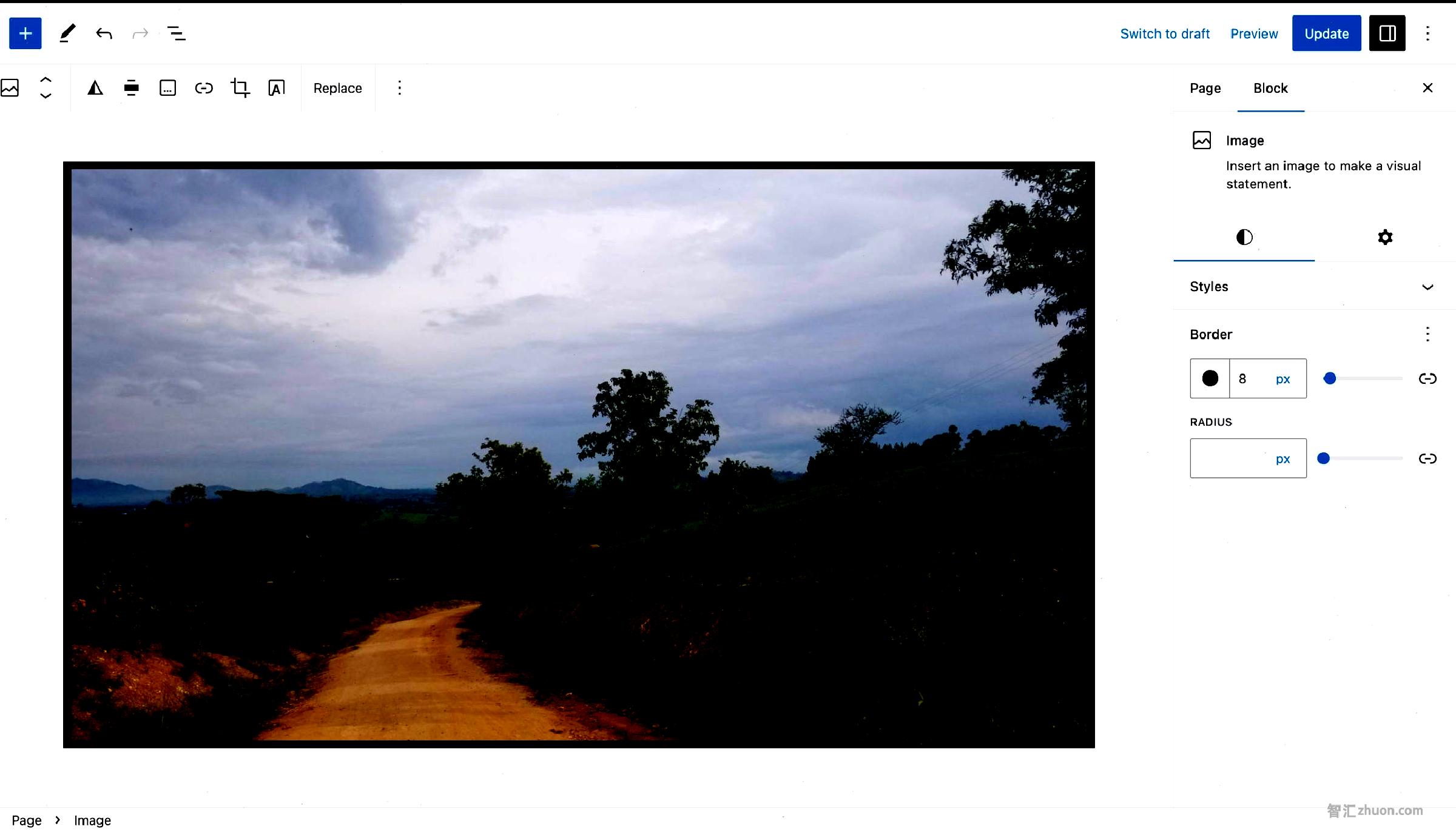 WordPress post editor with an image of a rural dirt road in the content canvas. It has a black border around it.