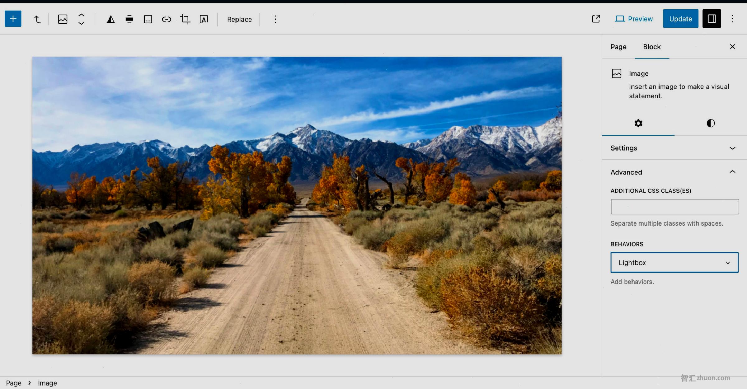 WordPress post editor with an image of a dirt road leading toward mountains. In the Block sidebar, the Lightbox feature is selected under the Behaviors control.